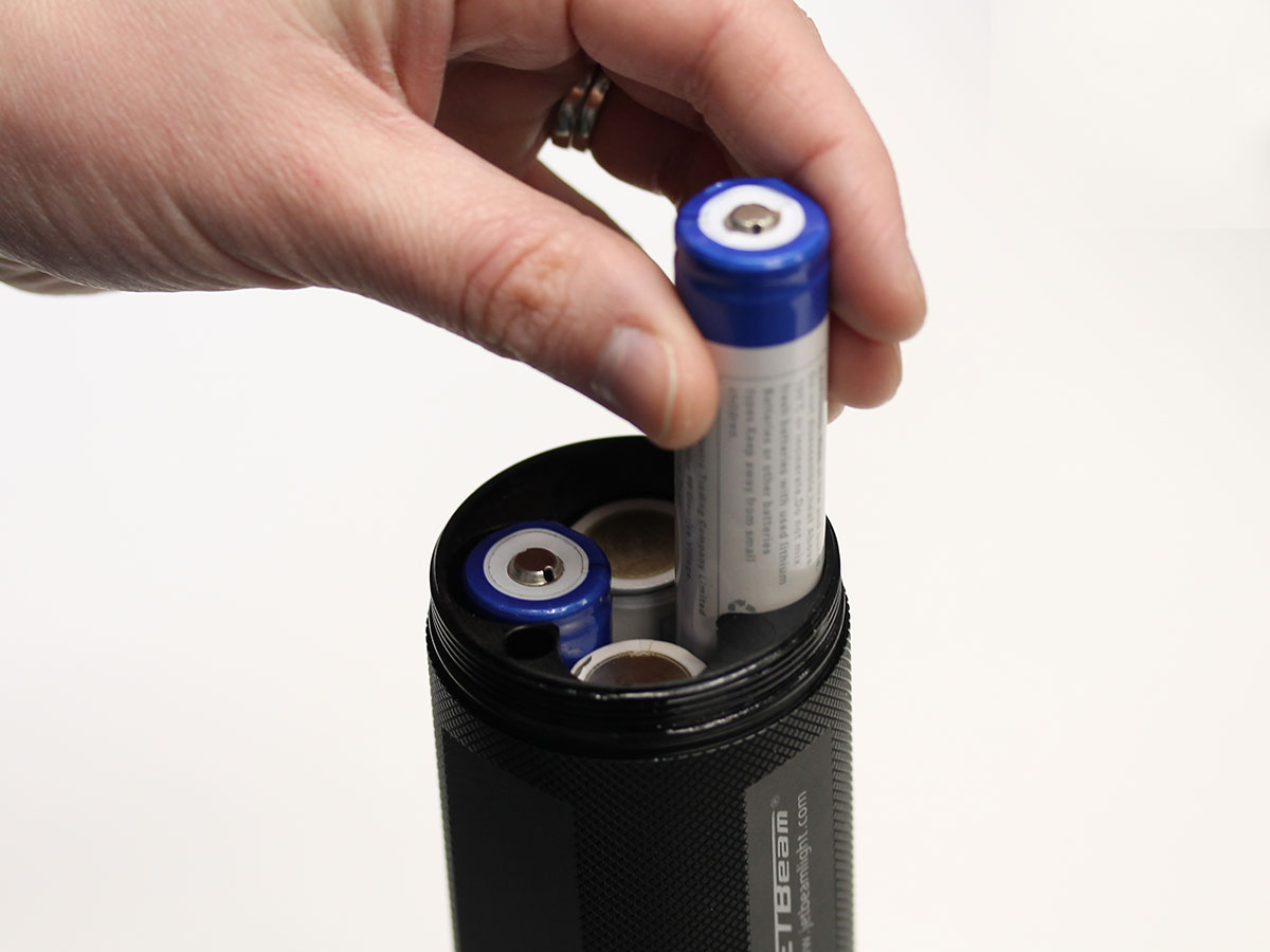 inserting batteries into flashlight